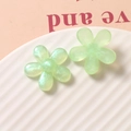 Dettaglio di fiori in resina verde chiaro traslucidi e glitterati per gioielli fai-da-te - Verde