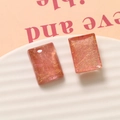 Close-up van roze transparante hars rechthoekige oorbellen met gouden draad textuur - 1 stuk (20x15mm) / Chrysantroze