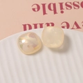 Detailed view of 18mm iridescent square resin charms with pearl sheen on ceramic plate - Champagne Gold