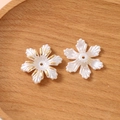 Gros plan de perles en forme de fleur avec bordure dorée pour bijoux artisanaux - Style Flocon de Neige