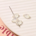 Detail van iriserende AB hars bladkralen met nerven voor het maken van DIY-sieraden - Bladvorm / 1 Stuk / Helder Wit / [productkenmerken] Dit Product Is Een Doe-het-zelf Handgemaakt Sieradenaccessoire Dat Eruitziet Als Losse Bladvormige Kralen Van Glas Of Acryl. De Kralen Zijn Transparant Met Een Iriserende Glans En Het Oppervlak Is Gegraveerd Met Fijne Bladnerfpatronen. De Afbeelding Toont Drie Kralen Geregen Op Een Zilveren Metalen Naald En Één Losse Kraal Platliggend. [visuele Presentatie] Echte Foto. Er Is Gebruikgemaakt Van Een Diagonale Compositie Met Een Beige Gestreept Tafelblad Als Achtergrond En Een Rood Kartonnen Accent In De Linkerbenedenhoek Dat De Visuele Focus Benadrukt. De Afbeelding Is Van Hoge Resolutie Met Zachte Belichting. Hoge Esthetische Waarde Algemene Score 85 Geen Duidelijke Visuele Gebreken. [tekstinhoud] Alleen In De Linkerbenedenhoek Van Het Kartonnen Rekwisiet Staat Een Onvolledig "ble"-teken Dit Is Inherent Aan De Tekst Op Het Rekwisiet En Vereist Geen Verdere Bewerking. [logistiek Label] Geen. [inbreukrisico] Productinbreuk: Geen; Achtergrondinbreuk: Geen. Inbreukkans 00. [productparameters] Gedetecteerd: Bladvorm Iriserende (ab-kleur) Glans Doe-het-zelf Handgemaakt Accessoire.