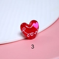 Makrofoto einer roten Herz-Glasperle mit weißem Love-Schriftzug und rosa Herz-Detail - Love Text Rosa Herz Stil (3#)