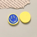 Macro detail of two-tone smiley face resin pendants for DIY jewelry and crafts - Blue and Yellow