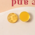 Macro shot of 16mm yellow resin geometric charms with water ripple and smooth texture - Yellow