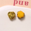 Dettaglio macro di ciondoli a rosa in resina 3D con finiture metalliche e gialle - Oro