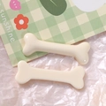 Dettaglio macro di due ciondoli in resina a forma di osso per gioielli e accessori DIY - Bianco