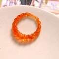 Dettaglio ravvicinato di anello in resina arancione traslucida con trama a spirale ritorta - Anello Vuoto