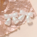 Close-up of glittery iridescent resin bows with scalloped edges for DIY accessories - Bow