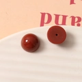 Détail macro de perles demi-rondes en résine rouge brique 12mm avec surface lisse et trou central - Rouge brique (6)