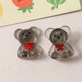 Detailed macro view of two grey translucent resin bears with red bows for DIY crafts - Black