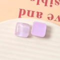 Dettaglio macro di orecchini a lobo quadrati in resina viola da 15mm con brillantini - Viola