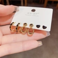 Detailliertes Set aus schwarzen Herzohrsteckern und goldenen Creolen in der Hand - Emaille Herz Set (J04-) / Gold