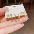 Detailaufnahme goldener Ohrringe mit Zirkon-Schmetterling und Herz-Anhängern - Zirkonia Herz Schmetterling Kette Kombination (J04-) / Gold