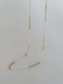 Detailed close-up of 18k gold plated textured metal rings and elegant pearl body chain - Gold
