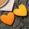 Handgefertigte orangefarbene Beflockung und glatte Herzanhänger auf schwarzem Papier - Orange