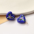 Detailed view of deep blue heart-shaped glass beads with delicate hand-painted pink rose petals - Klein Blue Heart