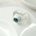 Macro shot of creative square acrylic ring featuring a realistic green eyeball design - Clear White