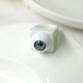 Macro detail of white square resin ring featuring a realistic blue eyeball design - White