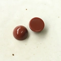 Vista macro di cabochon in resina rosso scuro lucidati per orecchini e accessori fai da te - rosso-marrone