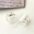 Detail of mini clear round resin hair clips with golden spring on a minimalist background - Clear White