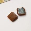 Detail showing the square dark brown leather texture and silver metal base of the button - Square / Brown