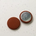 Detailed view of round brown checkered fabric buttons with magnetic metal backing for DIY - Orange