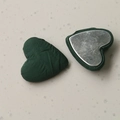 Detail of dark green satin heart charms showing the smooth fabric front and silver metal back - Dark Green