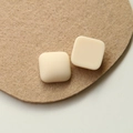 Detail view of square matte cream resin patches for DIY jewelry on felt pad - Milk White