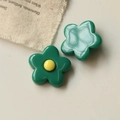 Close-up of green resin flower charms with yellow center for DIY jewelry making - Green