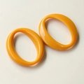 Vista detallada de dos colgantes ovalados huecos de acrílico naranja para hacer joyas - Naranja