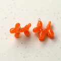 Close-up of orange resin balloon dog pendants with metal rings for DIY jewelry crafting - Orange Red