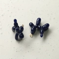 Macro detail of glossy dark blue balloon dog charms with gold metal rings for DIY jewelry - Klein Blue