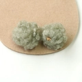 Macro detail of light green plush pompom charms with golden loops for DIY jewelry making - Grey Green