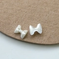 Vista macro de adornos para uñas de resina perlada con forma de lazo para manicura DIY - Estilo Recubrimiento Blanco Crema (3)
