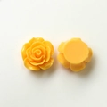 Macro view of yellow resin rose charms for DIY jewelry showing front and flat back - Orange