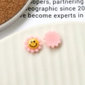 Macro view of colorful resin flower beads with smiley faces for DIY jewelry making - Pink