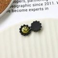 Macro shot of colorful acrylic sunflower charms with smiley faces for DIY accessories - Black