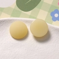 Dettaglio di ciondoli rotondi in resina opaca e lucida giallo crema per gioielli DIY - Beige