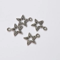 Set of four vintage silver alloy star-shaped pendants with bead edges and cutout centers - Star Style