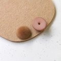Makroaufnahme eines beflockten Samt-Harz-Knopfes für DIY-Schmuck mit rosa Harzbasis und brauner Textur - Braun