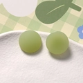 Dettaglio degli orecchini a perno tondi in resina verde chiaro opaco con finitura satinata - Verde
