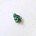 Macro shot of green glass Christmas tree bead with red and white festive dotted patterns - Christmas Tree