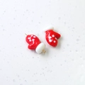 Macro view of red and white polka dot glove charms for DIY jewelry making - Christmas Mittens