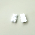 Detailed macro view showing white gummy bear resin charms on a light green background - Creamy White