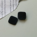 Dettaglio di accessori per gioielli in velluto nero quadrato con texture morbida - Nero