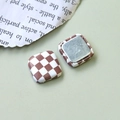 Détail d'un bouton carré à damier marron et blanc avec texture textile et base métallique - Carré Damier Marron