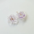 Macro shot of resin flower charm with purple dried petals and gold beads detail - Purple