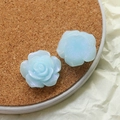 Macro view of light blue resin rose charms with iridescent shimmer and petal detail - Blue Rose