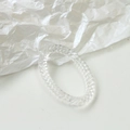 Macro shot of spiral textured transparent acrylic ring on artistic white paper - Clear White