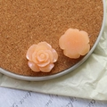 Detailed macro view of two pink resin rose flower charms with subtle glitter finish - Orange Rose